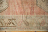 Distressed Oushak runner's abrashed pale dusty raspberry field and geometric serrated leaf border.