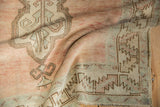 Distressed pile texture and serrated border design in soft raspberry and silver tones.