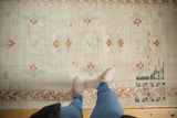Soft distressed pile of vintage Oushak rug with faded ivory and copper geometric motifs.