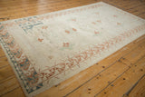 Vintage distressed Oushak rug corner with copper, blue geometric floral border.