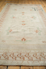 Distressed texture with copper and antique ivory reciprocating geometric floral border.
