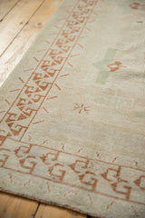 Vintage distressed Oushak rug's soft pile and chestnut brown geometric border.