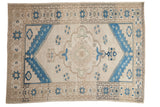 Vintage Distressed Oushak carpet: ivory field, indigo blue scalloped medallion, starburst border.