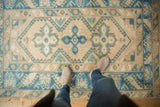 Geometric starburst and serrated leaf patterns on a distressed vintage Melas rug.