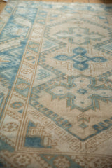 Distressed vintage Turkish Melas rug pile in blue and ivory, showing geometric border and field.