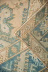 Distressed pile, visible foundation, and striped barber pole border on a vintage Melas rug.