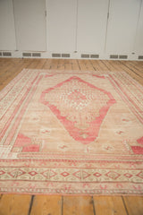 Distressed Oushak carpet border featuring pinwheel finned and plant motifs, cochineal red, antique ivory.