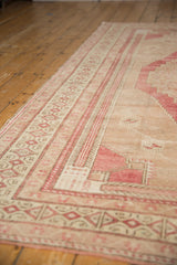 Vintage distressed Oushak rug border with raspberry and beige plant motifs.