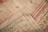 Distressed vintage Oushak rug showing pile texture and hand-knotted geometric border detail.