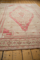 Lower border of vintage distressed Oushak rug with geometric forms in dusty red.