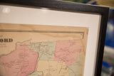 Black frame, white mat, and 1860s Bedford NY map with a small corner rip.
