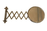 Antique beveled glass accordion shaving mirror with fleur de lis hardware and darkened metal patina.