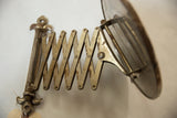 Vintage accordion shaving mirror's aged metal extension with darkened patina and rust marks.