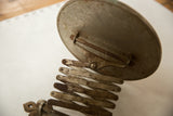 Close-up of antique shaving mirror's accordion arm with darkened, rusted patina.