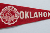 Close-up of vintage University of Oklahoma felt pennant, showing white seal on red felt.