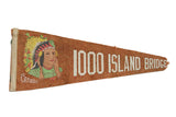 A vintage rust-colored felt souvenir pennant for the 1000 Island Bridge, featuring a Native American graphic.