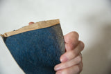 Stitched tan fabric header on the textured blue felt of a vintage pennant.