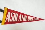 Angled view of the red Ashland Oregon pennant highlighting the felt texture and yellow binding.