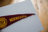 Vintage University of Minnesota maroon felt pennant, gold 'MINNESOTA' text and frayed tip.