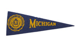 Vintage 1950s University of Michigan felt pennant with yellow seal and navy blue text, 3.5x9.5 inches.