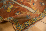Folded corner of an antique Tabriz rug showing the firm Sennehbaft weave and low pile with visible knot heads.