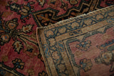 Folded corner of a vintage Farahan Sarouk rug revealing its hand-knotted foundation and side cord selvage.
