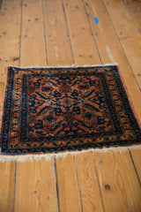 Vintage Lilihan rug corner, featuring terracotta rose and navy blue floral border with fringe.