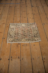A vintage Farahan Sarouk square rug with distressed floral motifs, seen from an overhead angle.