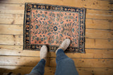 Top right corner of vintage Mohajeran Sarouk rug with dusty rose field and floral vine navy border.