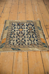 Vintage Caucasian rug upper left corner, geometric navy and beige pattern, serpent design border, and intact selvage.