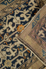 Geometric navy and tangerine pile of vintage Caucasian rug revealing woven foundation and selvage.