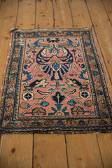 Faded raspberry field with blue arabesque florals and meandering vine border on a Lilihan rug.