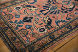 Vintage Lilihan rug corner with faded raspberry field, detailed floral borders, and machine-bound end.