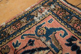 Vintage Lilihan rug corner detail, faded raspberry, cobalt blue floral border with speckled motifs.