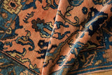 Intricate hand-knotted floral pattern in pale apricot, navy, and sky blue on a Lilihan rug.