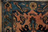 Vintage Lilihan rug corner showcasing intricate floral patterns, pale apricot field, blue border.