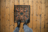 Vintage Lilihan square rug with dusty rose field, central floral, and colorful vinery.