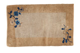 Antique Peking sampler rug with an open beige field, gold border, and blue floral corner sprays.