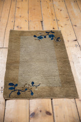 Antique Peking mat with a wide banded border framing its simple open field.