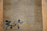 Cobalt blue floral blossom and vinery on the wide, banded corner of an antique Peking mat.