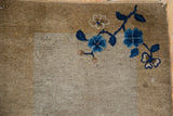 Detail of corner wear on an antique Peking mat, showing cobalt blue floral blossoms and a gold border.