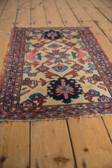 Lilihan rug's serrated geometric patterns in ivory, blue, red, showing worn ends.