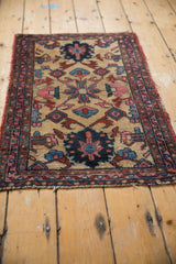 Upper right corner of vintage Lilihan rug with meandering vine border and tattered edge.