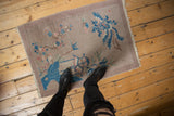 Art Deco pictorial rug with blue, beige, and dusty blush plant motifs.