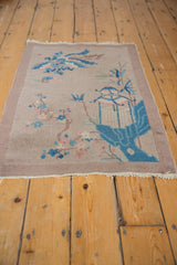 Corner of an Art Deco pictorial rug: sky blue gazebo, pink florals, dusty mauve border.