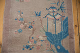 Detail of vintage Chinese Art Deco rug with blue gazebo, blush flowers on dusty mauve pile.