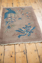 Vintage Art Deco rug's secure fringe and lower corner displaying blue and dusty mauve patterns.
