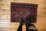 Intricate floral cross sections and geometric buds on a ruby red vintage Persian Lilihan rug.