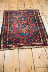 Detail of vintage Lilihan rug with raspberry red field, sapphire blue motifs, and original selvage.
