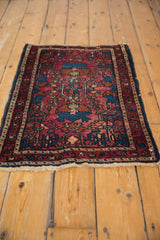 Vintage Lilihan rug corner detail, showing raspberry red field, sapphire blue motifs, and ivory fringe.